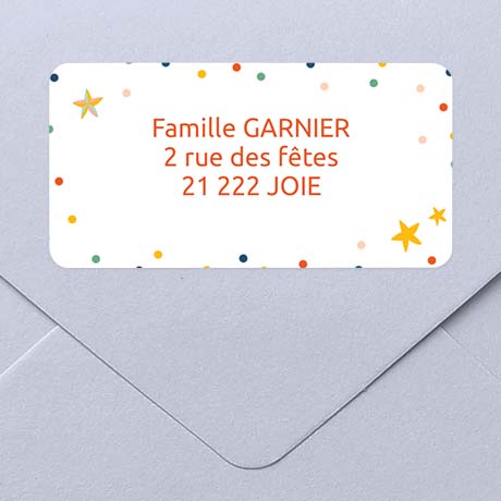 Une enveloppe et son étiquette d'adresse autocollante avec des petites étoiles de cuoleurs pour un envoi de voeux.
