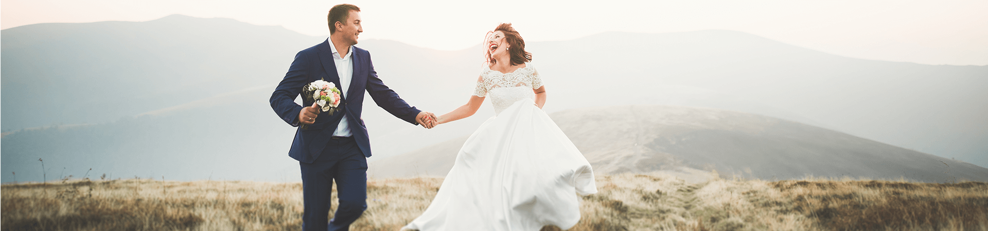 Un homme et une femme en costume et robe de mariée se tiennent la main et riggolent
