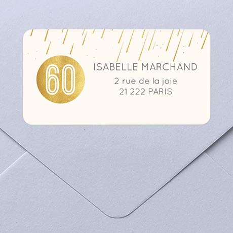 Une enveloppe et son étiquette d'adresse autocollante aux motifs dorés pour un anniversaire.